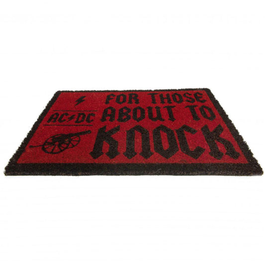 Red coir doormat featuring the phrase "For those about to knock" in black writing