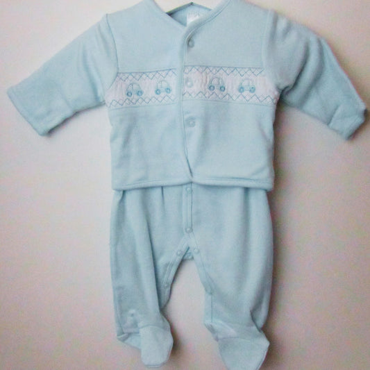 A blue smocked jacket and babygrow set with a car motif, displayed on a hanger against a white wall.