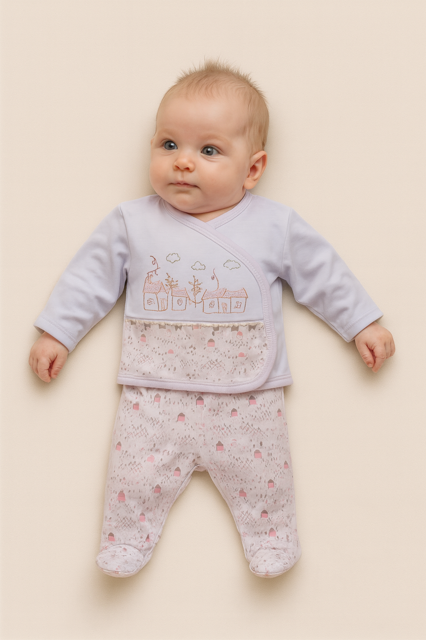 Baby wearing a light pink and white outfit with a pattern on a beige background