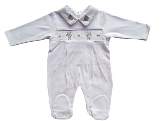 White smocked babygrow with bear face details and a snap closure.
