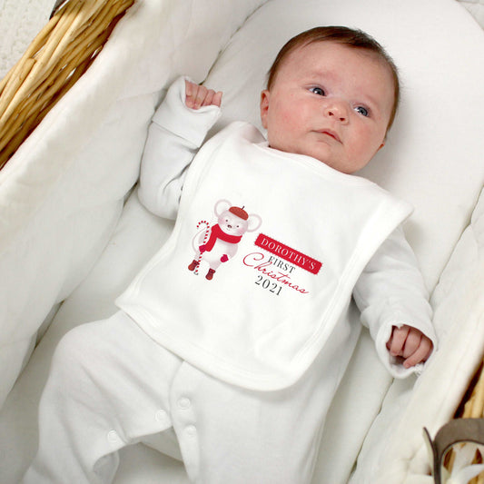 Baby laying in bassinet wearing a white sleepsuit and white bib personalised with 1st Christmas and cute mouse design. By Sweetlea Gifts