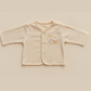 pale yellow baby jacket with star design on a beige background