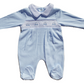 A blue smocked babygrow with a car motif, featuring long sleeves and snap closures.