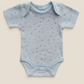 Light blue baby onesie with star pattern on a beige background