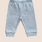 Light blue baby trousers with star pattern on a beige background