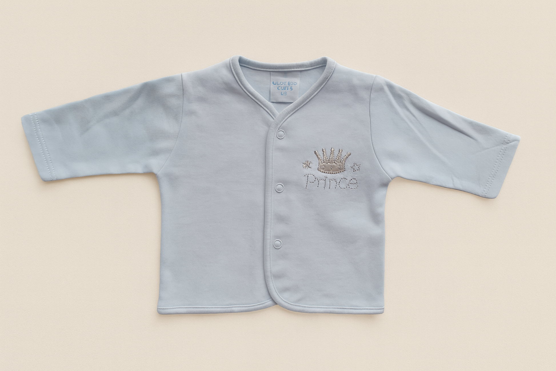 Light blue baby cardigan with 'Prince' and crown embroidery on a beige background