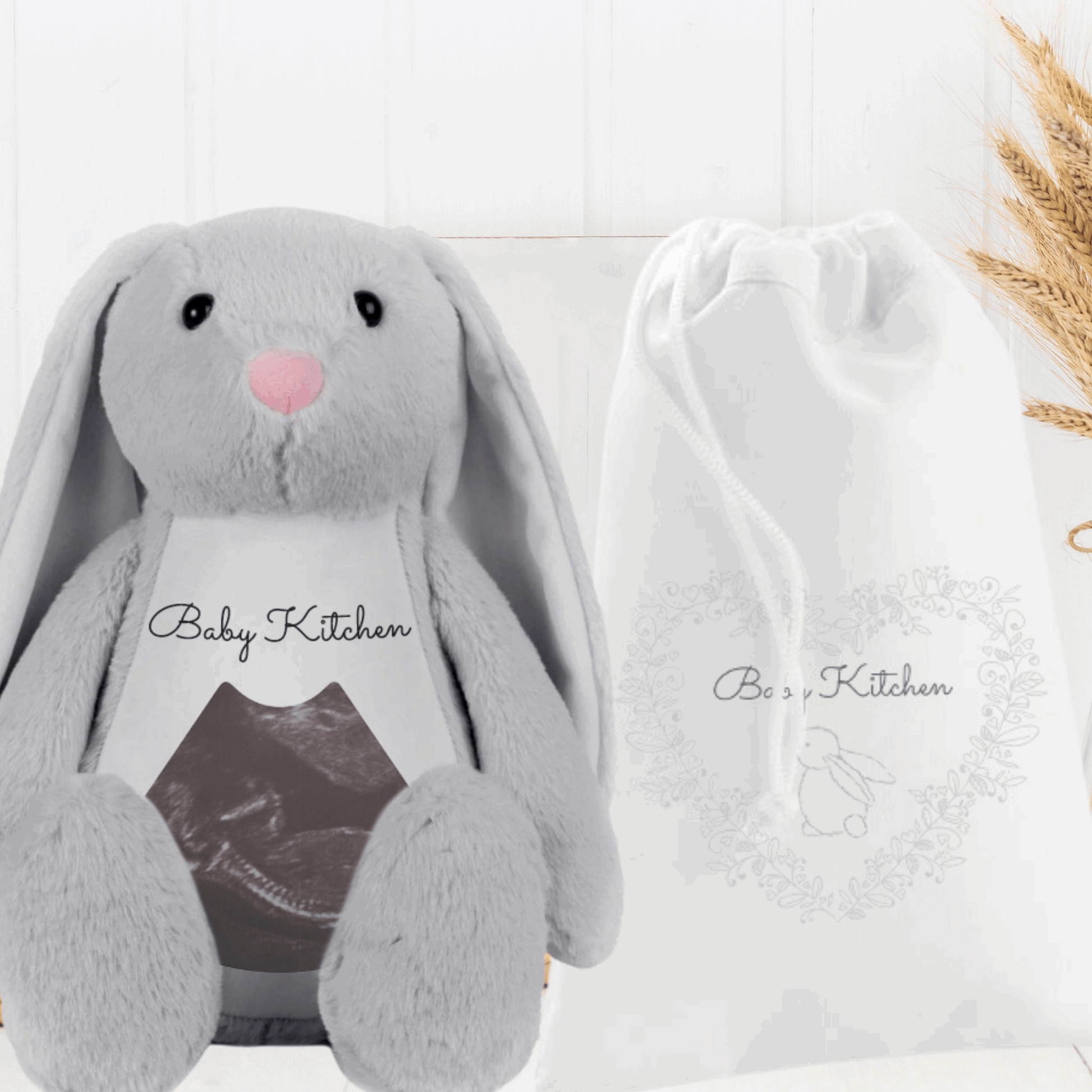 large grey plush bunny printed with a baby scan image and name sat next to a printed white gift bag By Sweetlea Gifts