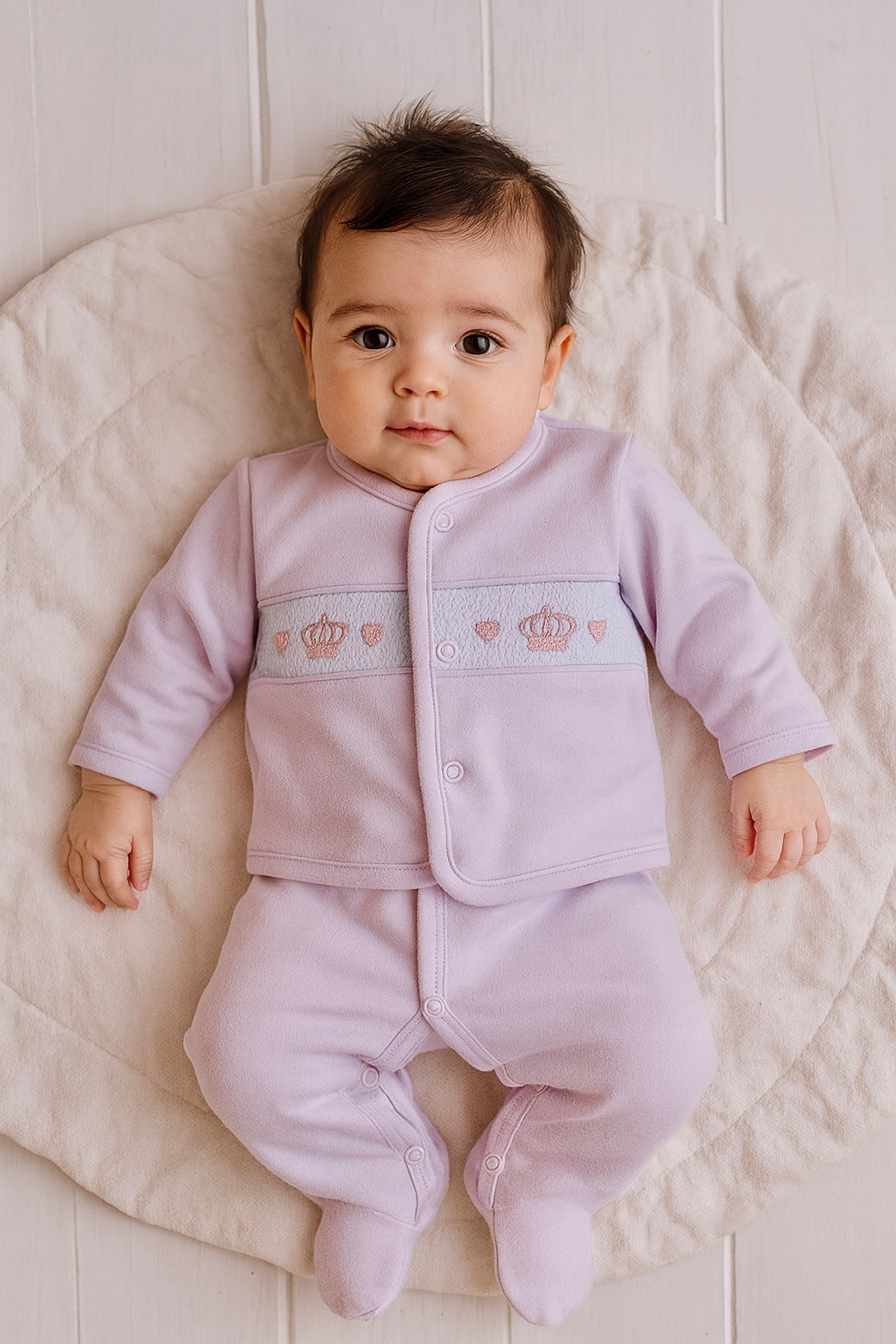 Baby girl in smocked crown and hearts Babygrow outfit