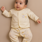 Cute baby in neutral yellow Babygrow and jacket set