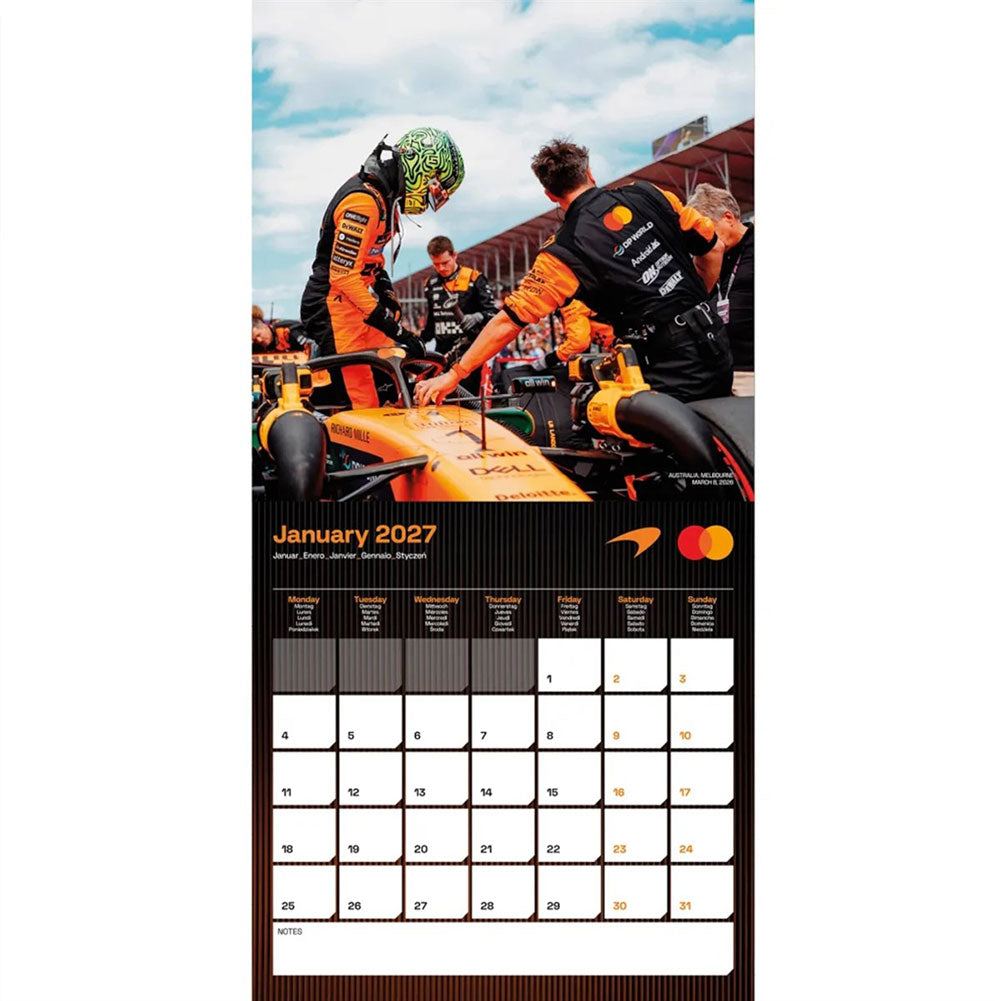 A vertical January 2027 wall calendar page featuring a Formula 1 race scene with an orange car and drivers, plus a black monthly calendar grid at the bottom with sponsor logos.