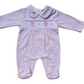 A pink smocked babygrow with a bear and paw motif, featuring a snap button closure.