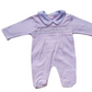 A pink smocked babygrow with a star pattern and a white trim on the collar.