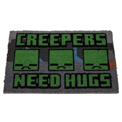 Grey coir doormat featuring the pixelated Creeper faces and the playful warning "Creepers Need Hugs,"