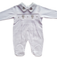 White smocked babygrow with bear face details and a snap closure.