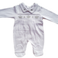 White smocked babygrow with a crown and stars motif on the front, featuring a snap closure.