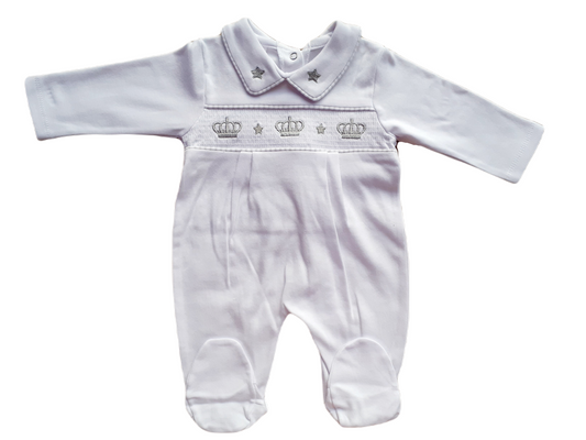 White smocked babygrow with a crown and stars motif on the front, featuring a snap closure.