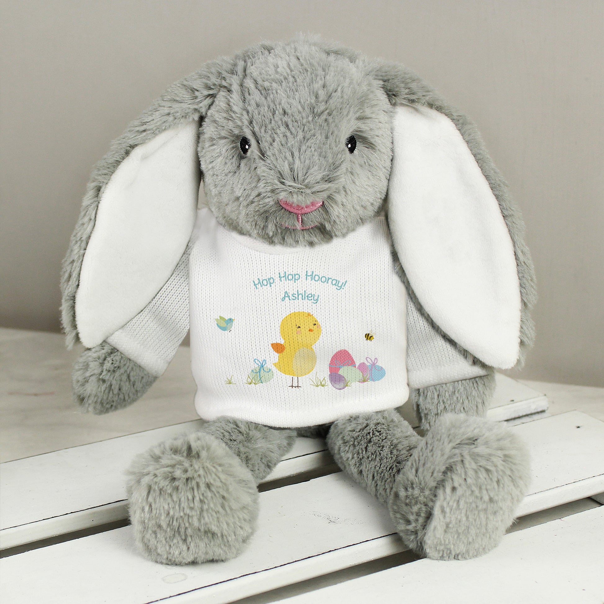 Grey soft plush rabbit toy wearing white t-shirt personalised with message and chick and easter egg image.