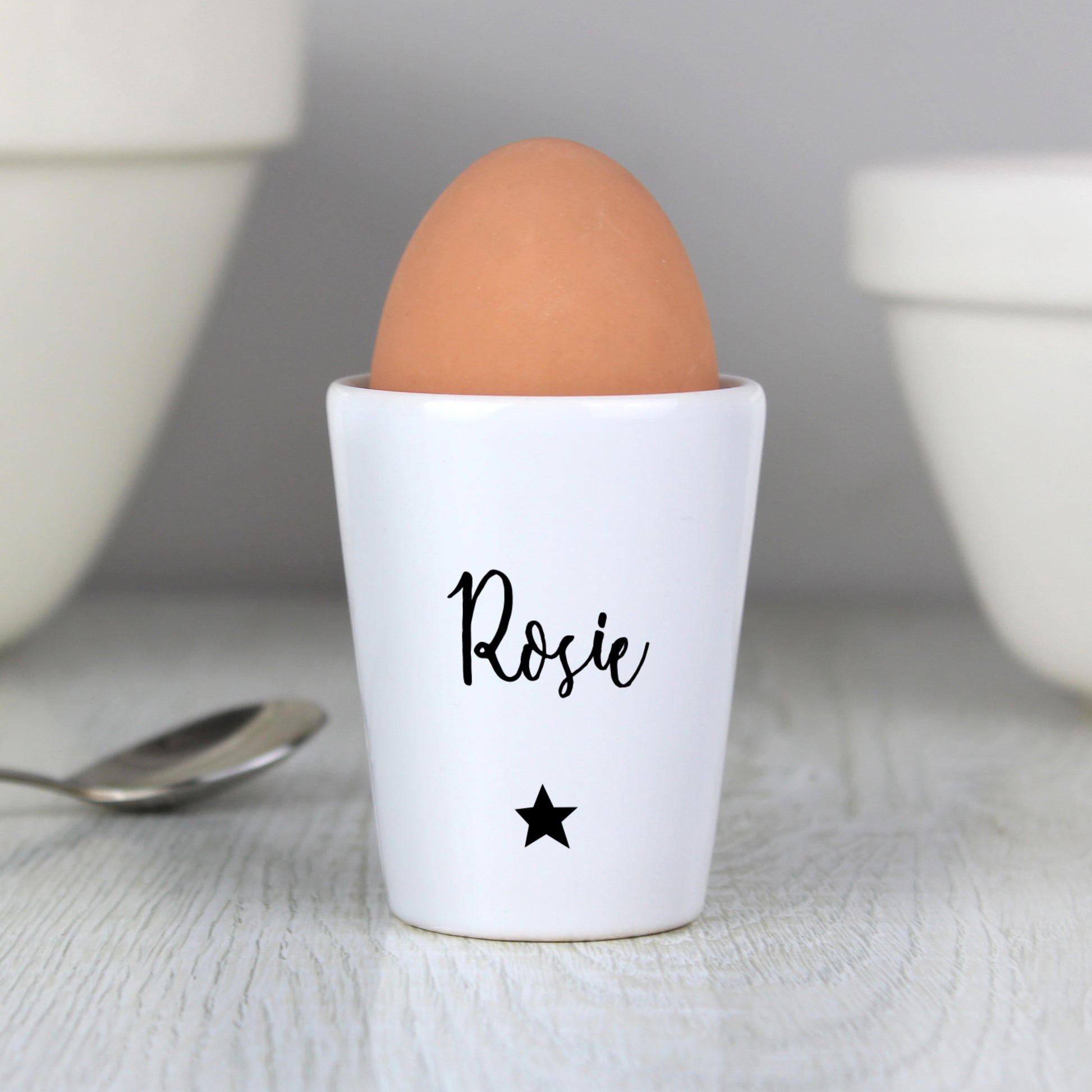 White ceramic egg cup personalised with name and star in black